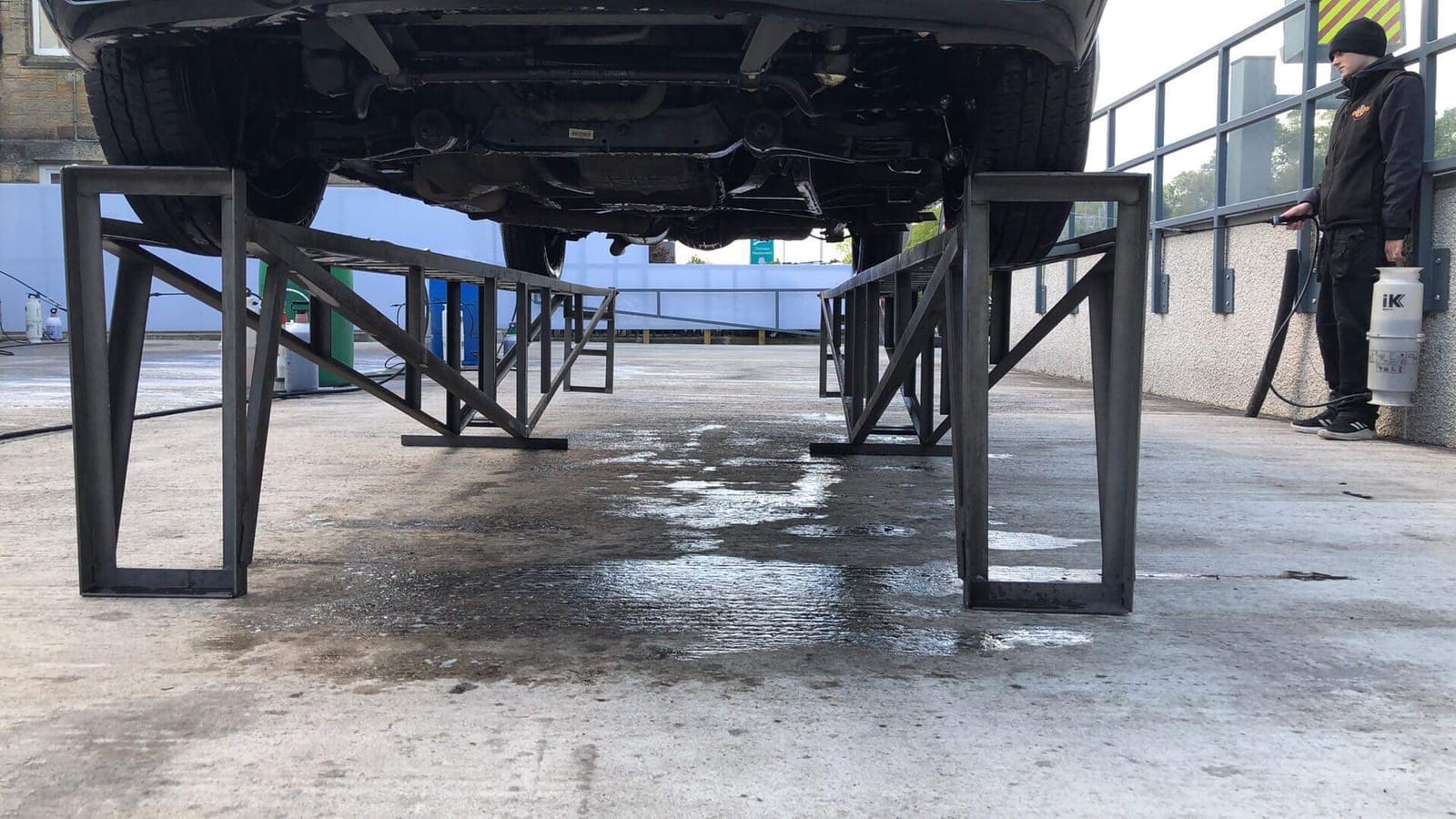 A car up on the Autofoam ramps while a team member sprays the underside