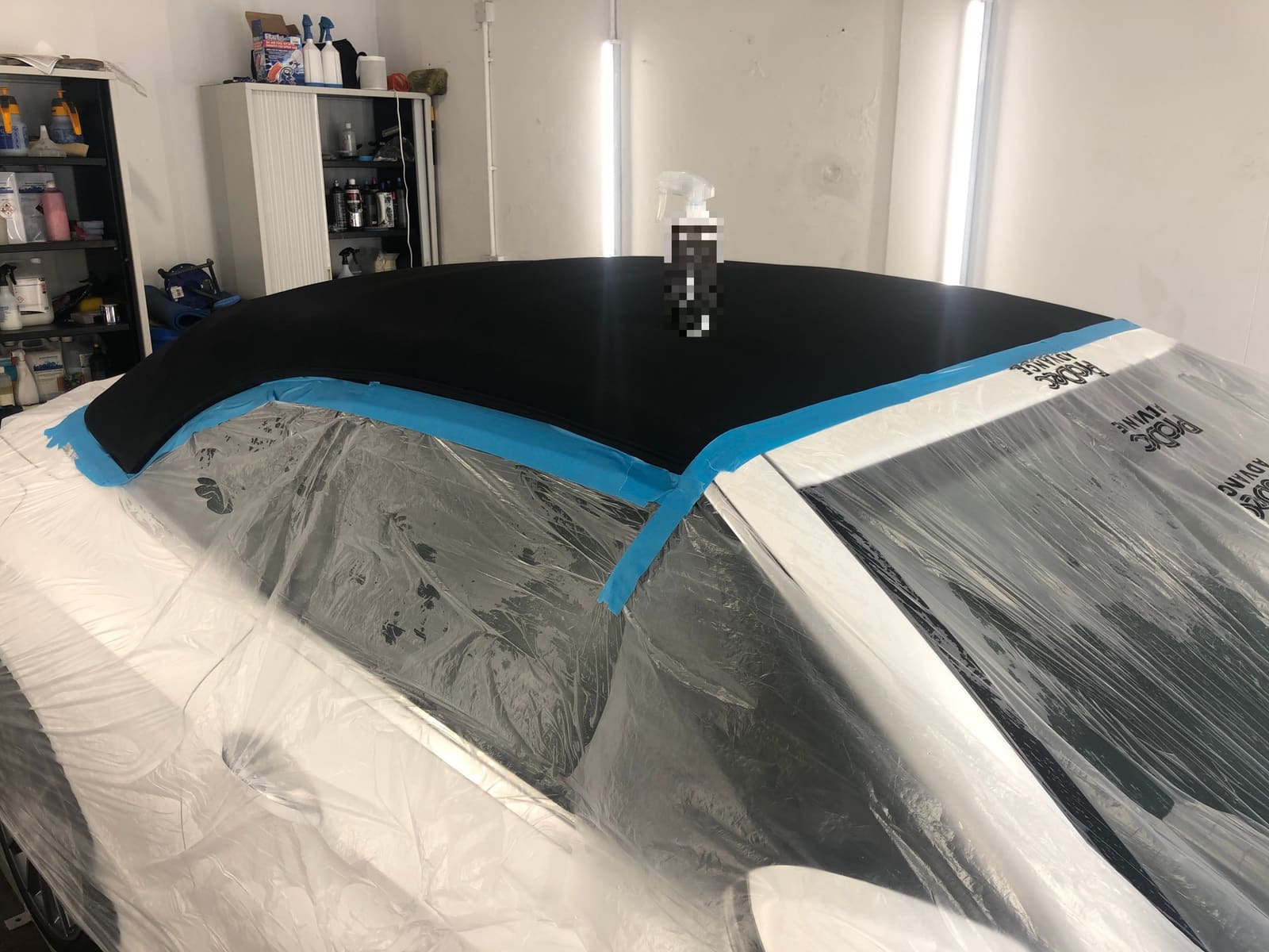 A convertible fabric roof masked off with blue tape, ready for the fabric protector