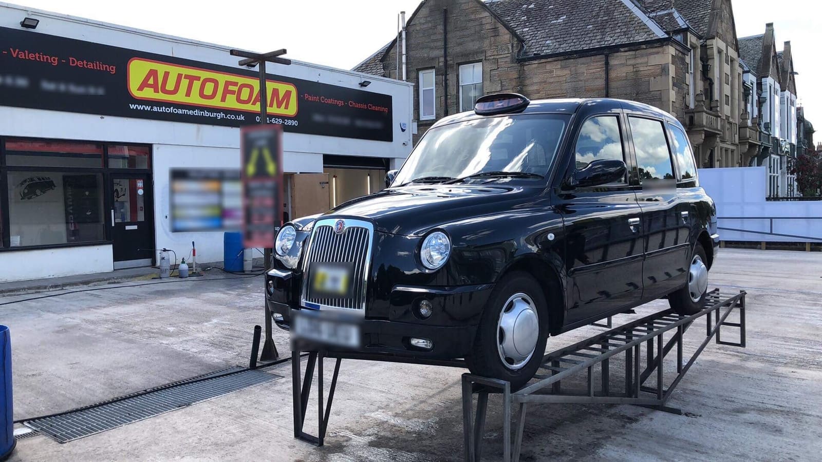 Black cab up on the ramps on the Autofoam forecourt, Corstorphine Road